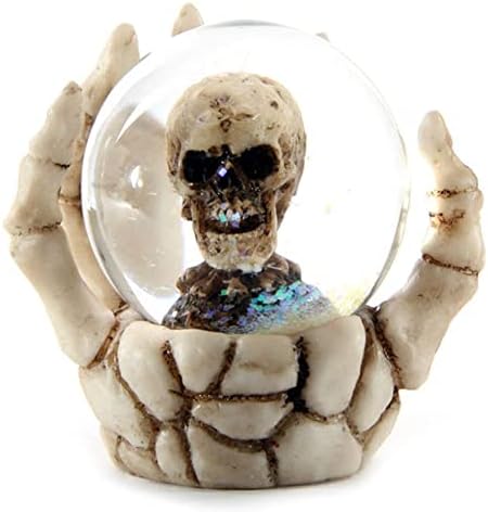 Mão do esqueleto de fantasia e globo de neve do crânio